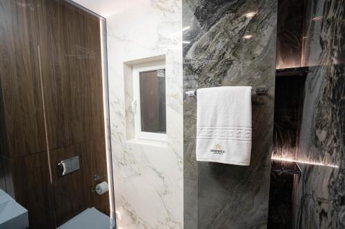 a bathroom with a toilet and a towel on a wall at Deluxe Aparthotel MARWELL RESIDENCE in Suceava