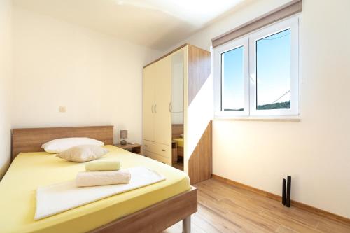 a bedroom with a bed and a window at Holiday Home Lydia in Slatine