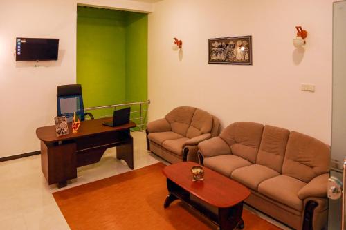 a living room with a couch and a desk at JAMI River Side Hotel & Yala Safari Place in Tissamaharama