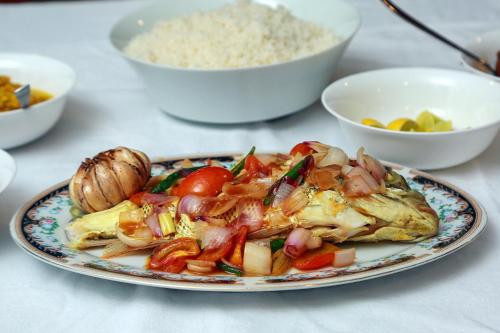 a plate of food with seafood and rice on a table at JAMI River Side Hotel & Yala Safari Place in Tissamaharama