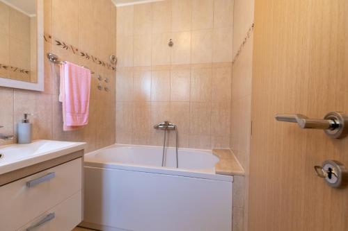 a bathroom with a white tub and a sink at Holiday Home Lydia in Slatine