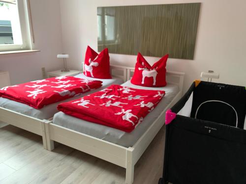 - 2 lits dans une chambre avec des oreillers rouges dans l'établissement Arche Noah Reilingen near Hockenheim and Walldorf, à Reilingen