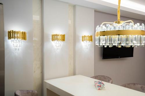 a dining room with a white table and a chandelier at Deluxe Aparthotel MARWELL RESIDENCE in Suceava