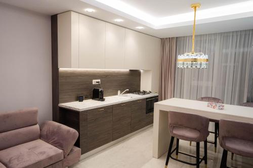 a kitchen with a sink and a bar with chairs at Deluxe Aparthotel MARWELL RESIDENCE in Suceava