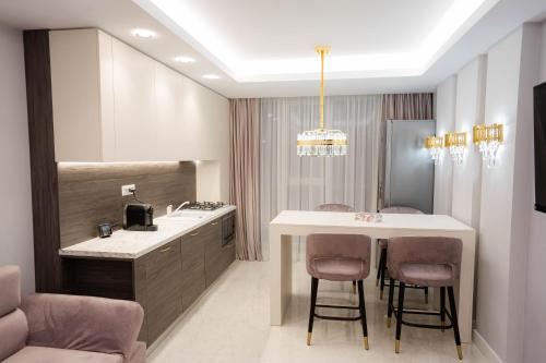 a bathroom with a sink and a table and chairs at Deluxe Aparthotel MARWELL RESIDENCE in Suceava