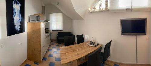 a dining room with a table and a tv on the wall at Ferienwohnung Schmid in Sankt Martin am Grimming