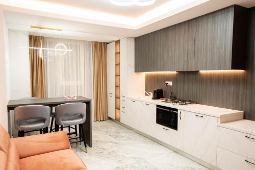 a kitchen with a table and chairs in a room at Deluxe Aparthotel MARWELL RESIDENCE in Suceava
