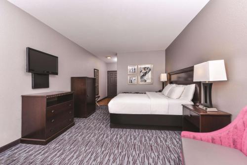 a hotel room with a bed and a flat screen tv at La Quinta by Wyndham Abilene Mall in Abilene