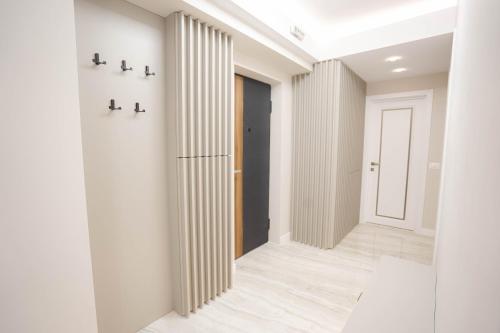 a hallway with white walls and a white door at Deluxe Aparthotel MARWELL RESIDENCE in Suceava