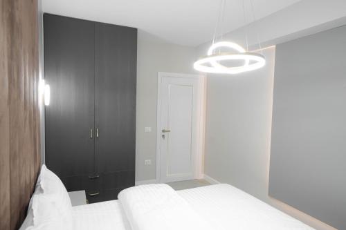 a bedroom with a white bed and a lamp at Deluxe Aparthotel MARWELL RESIDENCE in Suceava