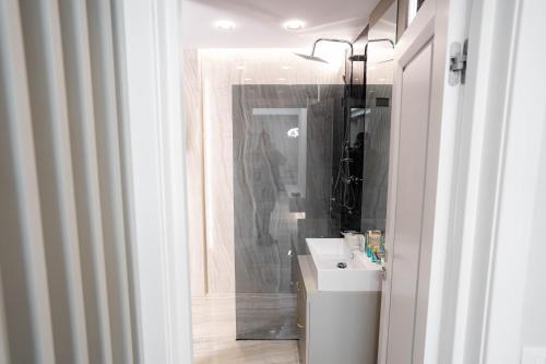 a bathroom with a sink and a mirror at Deluxe Aparthotel MARWELL RESIDENCE in Suceava
