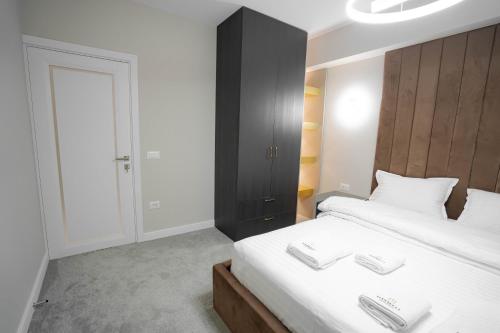 a bedroom with a bed with two white towels on it at Deluxe Aparthotel MARWELL RESIDENCE in Suceava
