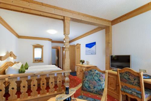 a living room with a bed and a television at Gasthof Bären in Holzgau