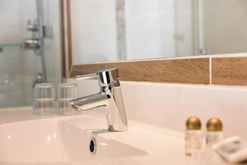 a bathroom sink with a faucet and a mirror at Gasthof Bären in Holzgau