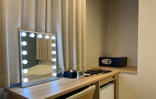 espejo sobre una mesa en una habitación de hotel en Remington Hotel, en Akashi