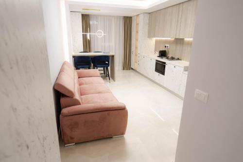 a living room with a couch and a kitchen at Deluxe Aparthotel MARWELL RESIDENCE in Suceava