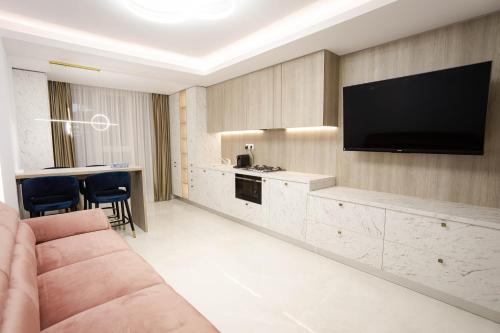 a living room with a couch and a flat screen tv at Deluxe Aparthotel MARWELL RESIDENCE in Suceava
