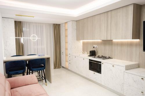 a kitchen with a counter and chairs in a room at Deluxe Aparthotel MARWELL RESIDENCE in Suceava