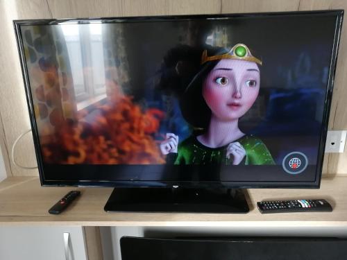a computer monitor with a doll on top of a desk at 69R Seawick 2 Bedroom Caravan . New for 2022 in Saint Osyth