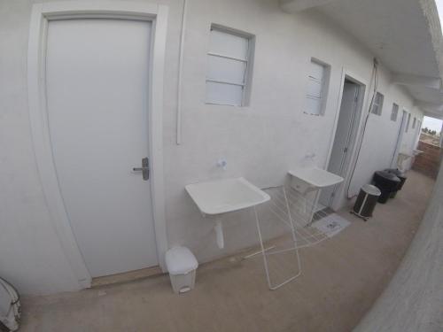 a bathroom with two sinks and a white wall at Flats Taiba Praia Centro in Taíba