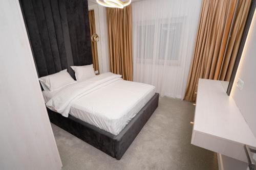 a bedroom with a bed with a black headboard at Deluxe Aparthotel MARWELL RESIDENCE in Suceava