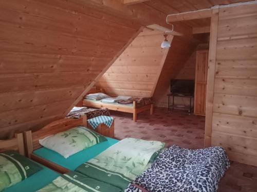 a room with two beds in a log cabin at Pokoje gościnne w górach in Kościelisko