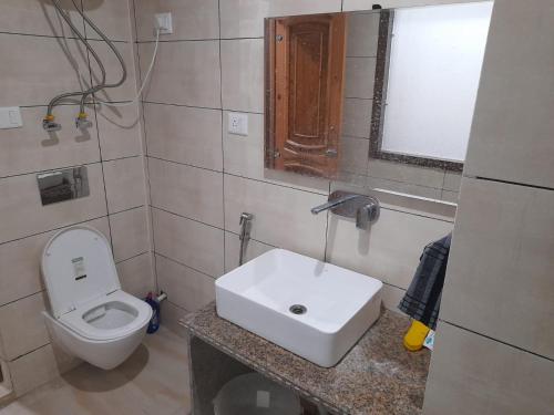 a bathroom with a white sink and a toilet at Hotel Zoon Dabb Srinagar airport kashmir in Srinagar