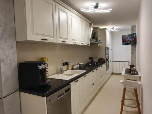 a kitchen with white cabinets and a sink at Apartament Luxury in Vişeu de Sus