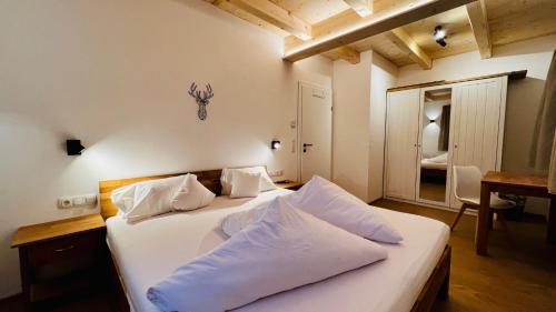 a bedroom with two beds with white pillows at Mountain Inn Chalets & Apartments in Walchsee