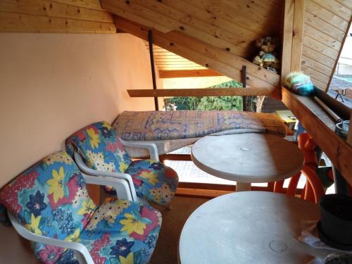 ヘーヴィーズにあるKároly Vendégházの椅子、テーブル、ソファが備わる客室です。