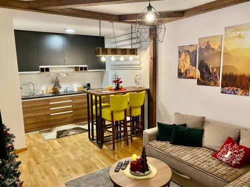 uma sala de estar com um sofá e uma cozinha em Zlatiborske Noći em Zlatibor