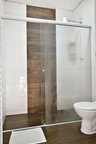 a bathroom with a toilet and a glass shower at HOTEL & HOSTEL RIBEIRAo in Ribeirão Preto