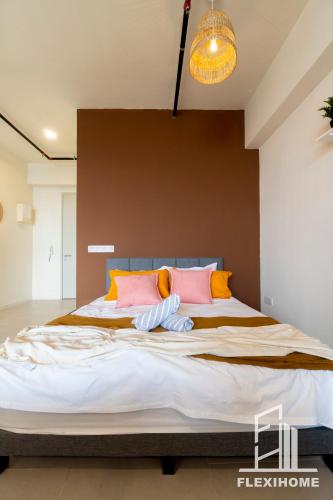 a bedroom with a large bed with pink and orange pillows at 9am-5pm, SAME DAY CHECK IN AND CHECK OUT, Work from Home, Comfy & Quiet Tamarind Suites-Cyberjaya by Flexihome-MY, in Cyberjaya