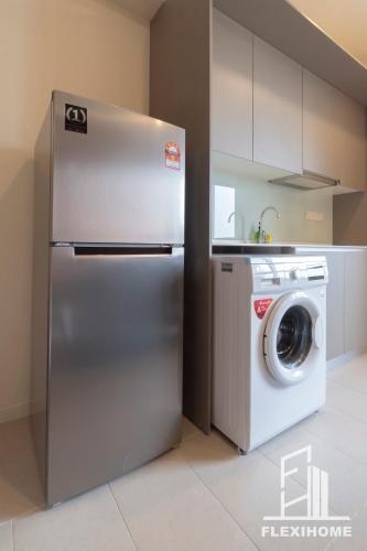 a stainless steel refrigerator in a kitchen with a washing machine at 9am-5pm, SAME DAY CHECK IN AND CHECK OUT, Work from Home, Comfy & Quiet Tamarind Suites-Cyberjaya by Flexihome-MY, in Cyberjaya