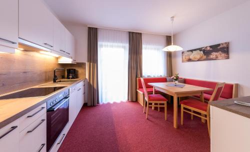 a kitchen with a table and a dining room at Landhaus Rosengartl in Schladming