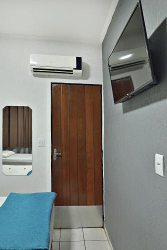 a bathroom with a wooden door and a room at HOTEL & HOSTEL RIBEIRAo in Ribeirão Preto