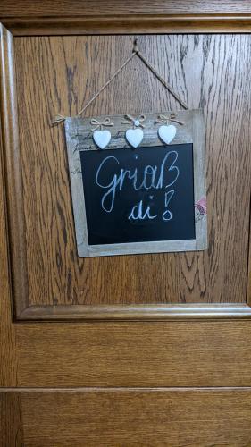 a sign on a wooden door with hearts on it at Ferienhaus Gertrud in Nesselwängle
