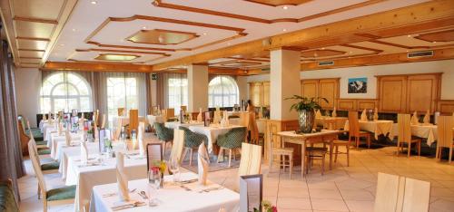 a dining room with tables and chairs in a building at Landhotel Latscherhof in Laces