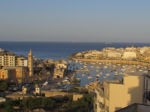 a view of a city with boats in the water at Panoramic Penthouse in Marsascala which enjoys sea and country views in Marsaskala