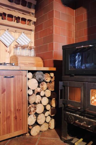 a stack of logs next to a stove at Chalet Kočna - I FEEL ALPS in Stahovica