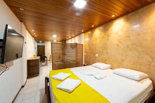 1 dormitorio con 1 cama grande con manta amarilla en Flat Pipa's Ocean - Apto 319, en Pipa