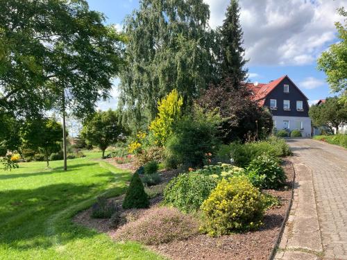 a garden in front of a house at Balkonzimmer Pension Volgenandt in Breitenbach