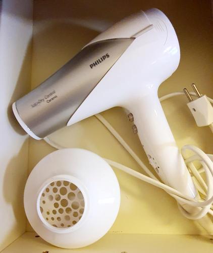 a white electric hair dryer sitting on top of a counter at 2 rooms Appartment "Home, Swiss Home" in Bilten