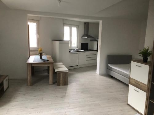 a kitchen with a table and a refrigerator and a table at Appartement Willa chez willi in Niederschaeffolsheim