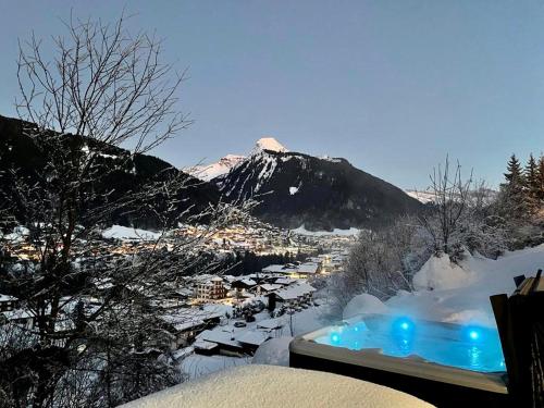 a hot tub in the snow with a mountain at Chalet le Timeris - Jacuzzi - Vue exceptionnelle in Morzine