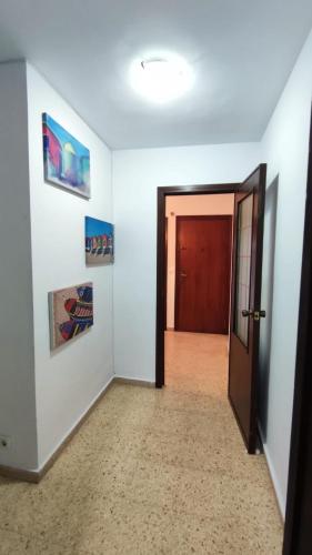 an empty hallway with a door and paintings on the wall at Habitación con cama doble, piso compartido en Avenida Blasco Ibáñez in Valencia