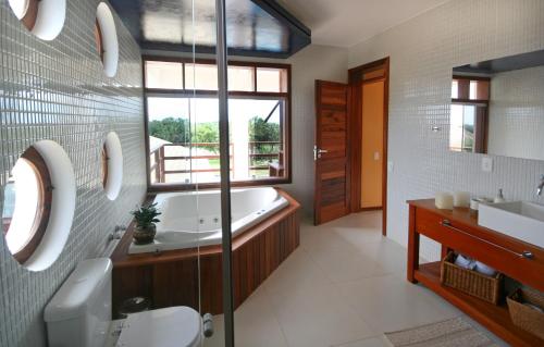 a bathroom with a tub and a toilet and a sink at Refúgios Parajuru in Parajuru