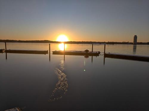 a body of water with the sun setting in the background at Ostsee Hausboot Schleswig Ostseeblick 1 in Schleswig