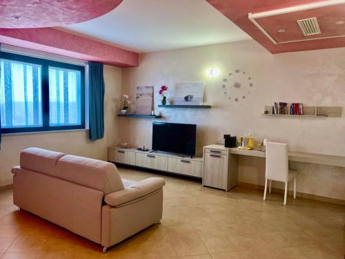 a living room with a couch and a desk and a tv at L'incontro in Trinitapoli