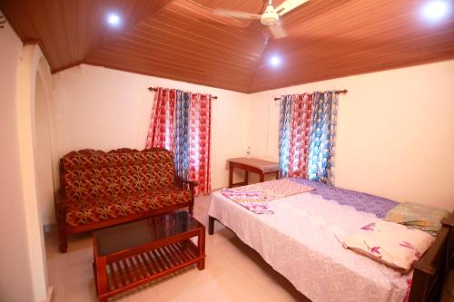 1 dormitorio con 1 cama y 1 silla en MUNROE LAGOONS, en Kollam